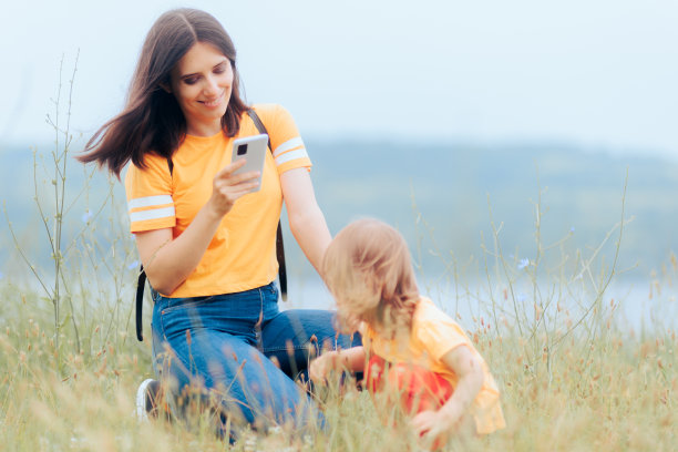母亲在拍女儿在大自然中玩耍的照片图片下载
