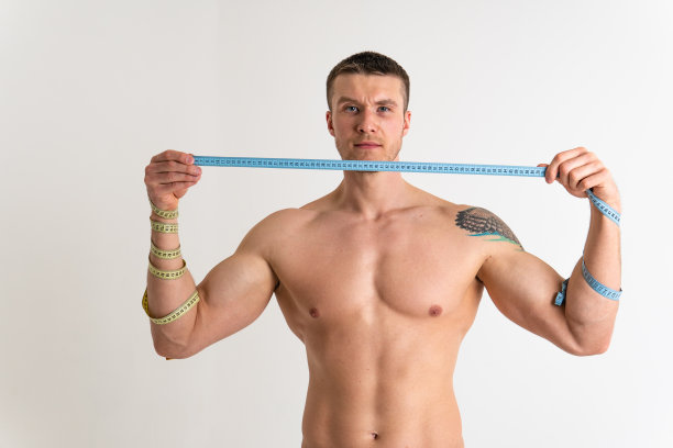 一名男子测量腰围一米，并在白色背景下孤立健身腰部，女性健美的生活方式美，生活方式白。20、Oss运动的美丽，成人运动的吸引带图片下载