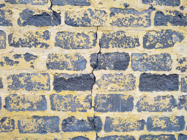 灰色煤渣砌块墙，漆面黄色剥落图片下载