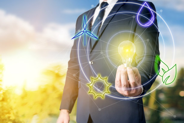 一位商人用可再生能源点亮了一个灯泡。环境可持续性、生态、节能理念图片下载