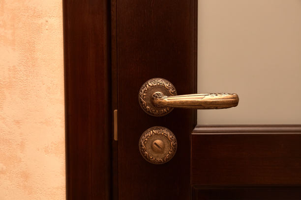 古铜色金属门把手，经典图案。室内设计细节。紧闭的门。副本的空间。特写镜头。美丽的家具。木质材料。棕色的色彩。复古或复古风格图片下载