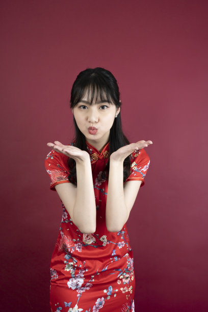 快乐亚洲年轻女子肖像，显示一个迷人和自信的微笑，显示姿势吻你图片下载