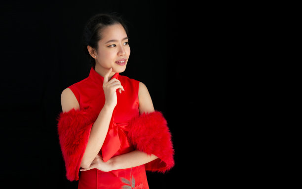 人像美丽开朗快乐的亚洲妇女穿着红色的服装，摆姿势，微笑，独自站在孤立的黑色背景裁剪和广告复制空间，庆祝中国新年。图片下载