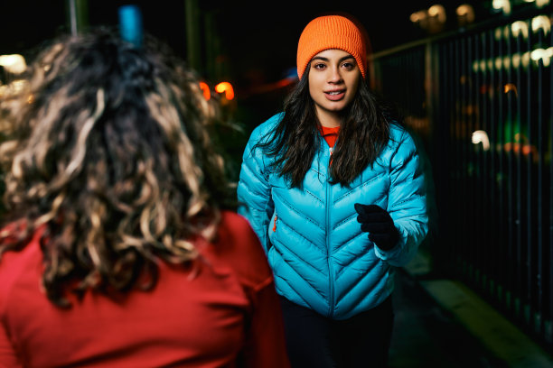 穿着暖和的衣服，适合夜间跑步的人在街上跑步，路过行人。图片下载