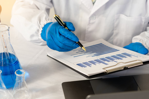 医生拿着一台笔记本电脑，旁边放着一支绘图笔和一个测试瓶。图片下载