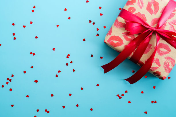 情人节礼盒和蓝色背景的心形纸屑。平躺，顶视图，复制空间。图片下载