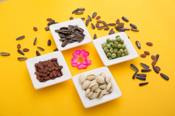 春节，农历新年，中国新年的概念。晒干的葵花子、莲子、西瓜和南瓜子被孤立在黄色的俯视图上图片下载