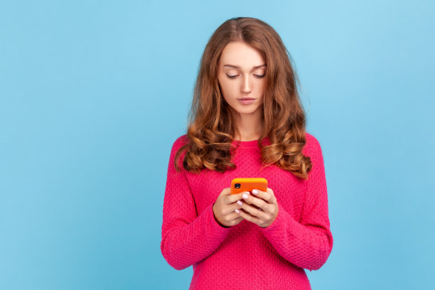 女人在手机上打字，在社交网络上阅读帖子，带着严肃的表情在线聊天图片下载