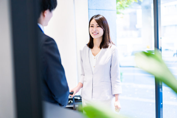 年轻女子与酒店员工交谈图片下载