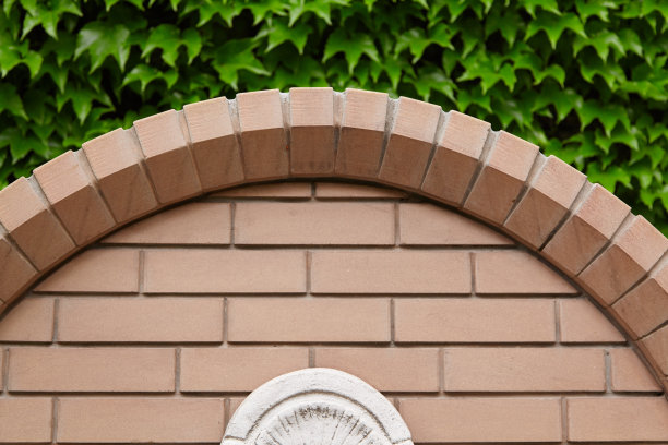 以绿叶为背景，用漂亮的砖砌成的拱门图片下载