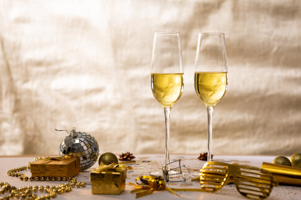 香槟长笛与装饰和礼品盒米色背景，复制空间图片下载