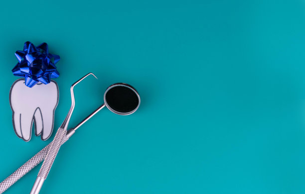 牙科医生白天牙齿和牙科器械在蓝色背景。文本的复制空间。图片下载