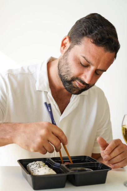 一个正在吃什锦寿司的人。加利福尼亚卷。图片下载