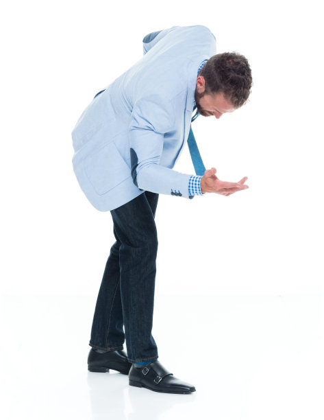 穿着牛仔裤的白人年轻商人在白色背景前鞠躬图片下载