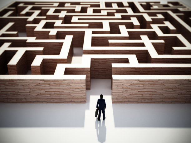 一个商人拿着公文包站在一个方形迷宫的入口处图片下载