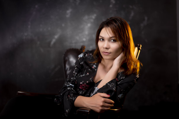 在黑色和纹理背景下看着相机的女人。图片下载