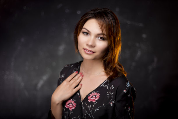 在黑色和纹理背景下看着相机的女人。图片下载