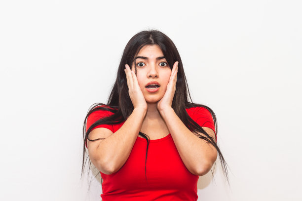 拉丁女孩，脸上带着惊讶的表情，双手放在脸上。图片下载