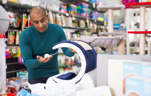 男子在商店挑选猫家具图片下载