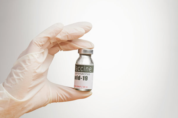 裁剪照片的医生手在医疗手套持有两个手指一瓶疫苗，健康和免疫概念。图片下载