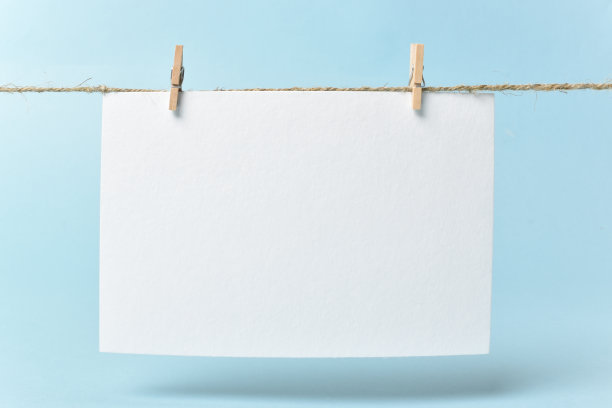 一张纸挂在蓝色背景的晒衣夹上。副本的空间。一张结婚，生日，周年纪念的明信片图片下载