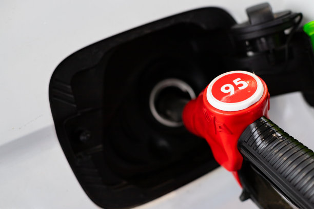 在加油站插入汽车油箱的95号燃油喷射枪。石油公司，价格增长理念。在加油站给汽车加油。汽车加油图片下载