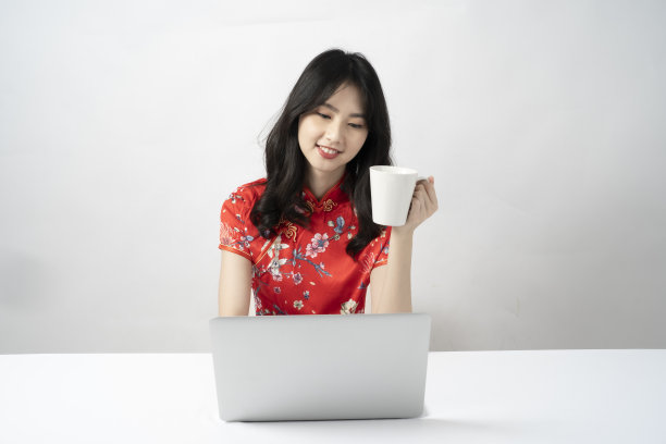 快乐亚洲年轻女子肖像，使用电脑视频会议和商务活动，饮用水。图片下载