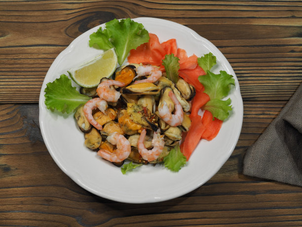 简单的沙拉，带皮的贻贝，腌生姜和青柠，放在木桌上的白色盘子里，平面布局。食谱为清淡小吃配以美味的海鲜，适宜饮食营养，俯视图图片下载