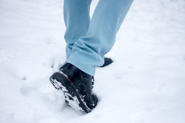 雪地里穿着靴子的男人的脚图片下载