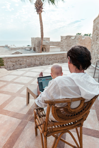 爸爸和他的小儿子带着笔记本电脑休息，作为一个自由职业者在假期工作图片下载