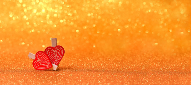 两个小的木制心明亮的金色灯光散景背景情人节卡片图片下载