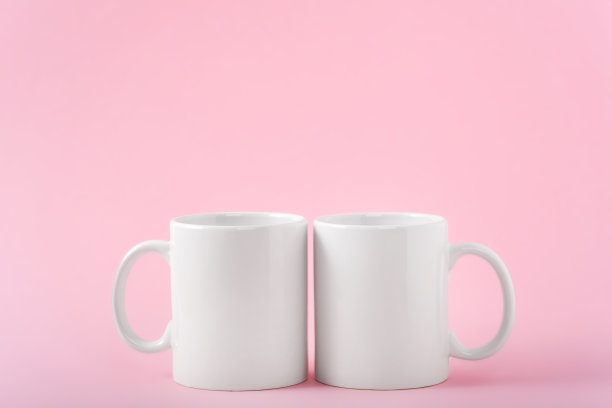 模拟两个白色咖啡杯或马克杯在粉红色的背景与副本空间图片下载