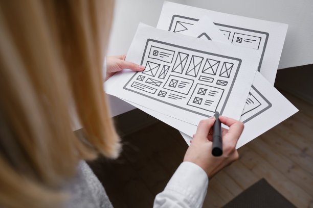 女设计师创建网站设计线框。草图，原型，框架，布局未来设计项目。UI和UX -用户界面，用户体验设计师。网页设计工作室的创意概念图片下载