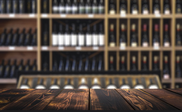 酒木桌背景。柜台上的酒瓶模糊不清。图片下载