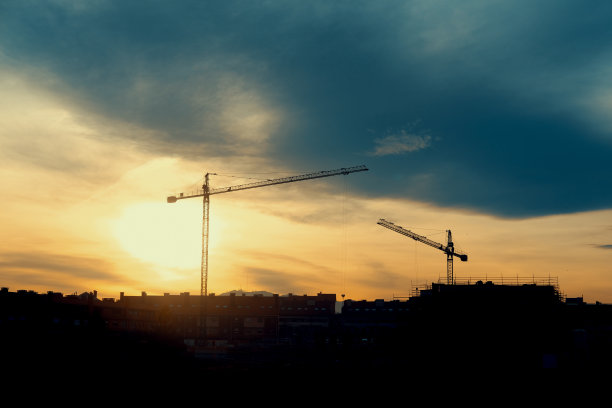 日落时分建筑工地上的起重机图片下载