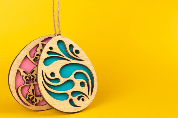在明亮的黄色背景上手工制作的木制复活节蛋，庆祝活动和春节概念照片图片下载