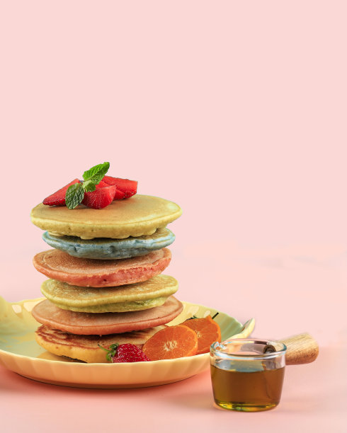 煎饼堆叠枫糖浆和树莓孤立在粉红色的背景上。家庭的早餐。图片下载