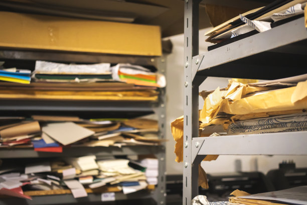 印刷厂仓库和金属货架用不同类型的纸张。工作流程，印刷行业概念照片图片下载