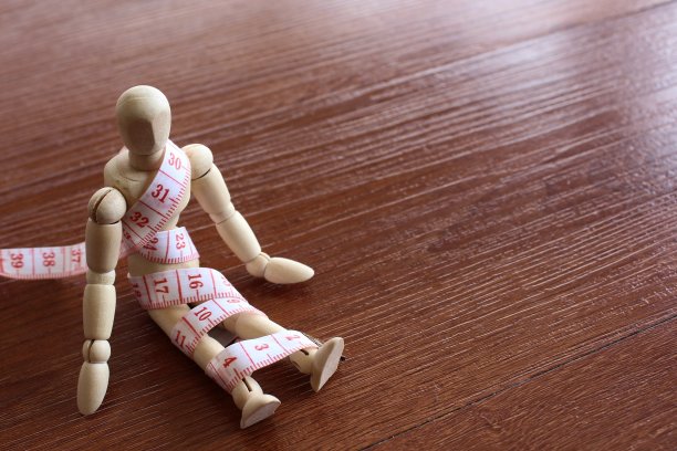 木制娃娃和卷尺与文本复制空间。图片下载