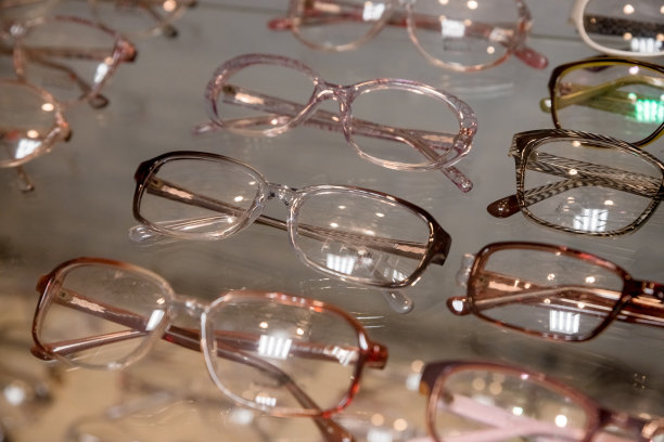 许多眼镜排在光学零售商店。丰富的配搭选择不同的眼镜架在眼镜店展示。光学商店。戴着彩色的现代眼镜。有选择性的重点。图片下载