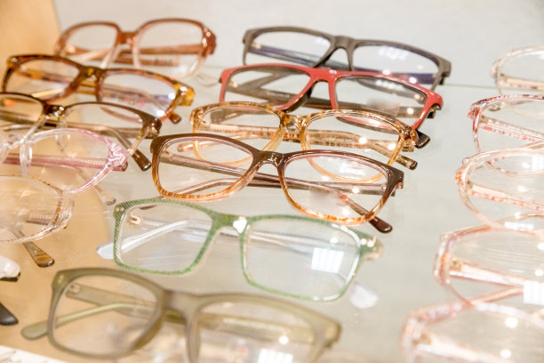 在眼镜店的墙上陈列着一架子时髦的眼镜。光学，保健和视觉的概念近距离眼镜在眼镜商图片下载