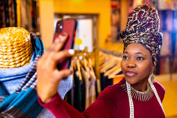 坦桑尼亚一位戴着蛇纹头巾的妇女正用手机相机自拍图片下载