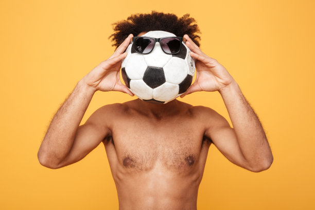 年轻的非洲男子赤膊上阵，用一只足球盖住头部图片下载
