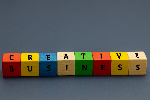 彩色的积木叠在一起，上面写着创意和商业海军蓝背景空白的空间概念创意和非传统的商业思维图片下载