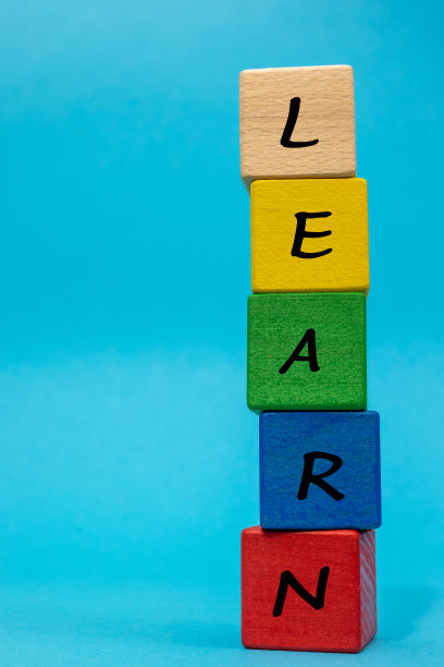 题词“学习”由蓝色背景上垂直排列的彩色方块组成，创意空间，儿童和成人发展和学习的概念，垂直照片图片下载
