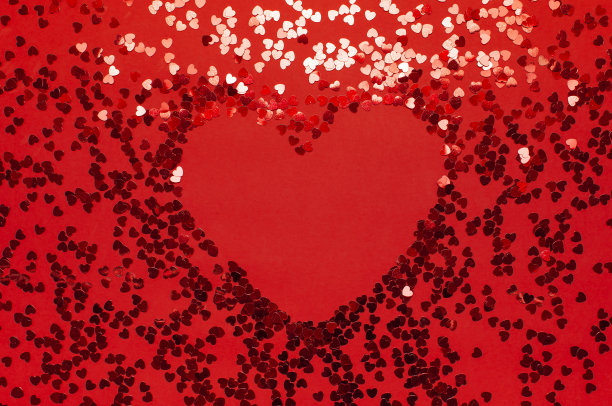 红色纸屑在红色背景上心形的框架顶视图平铺。节日背景，情人节，派对概念，爱情，生日，圣诞节或新年文字Copyspace图片下载