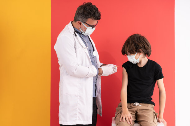专业成熟的医生给一个小男孩打针。图片下载