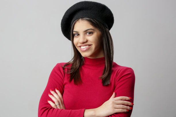 迷人的年轻女子的肖像在红色的连衣裙和黑色贝雷帽。图片下载