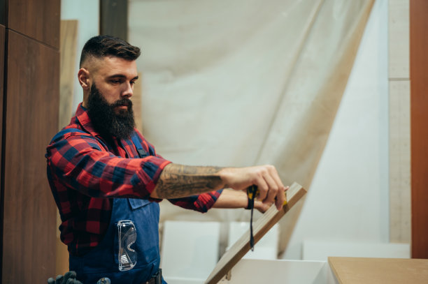 年轻男性木匠在车间工作，用仪表测量图片下载