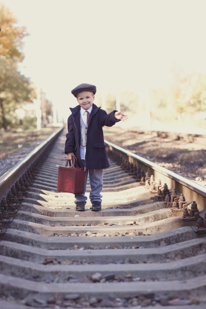 复古照片，一个孩子提着行李箱在枕边行走图片下载